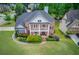 Aerial view of the two-story brick home showcasing mature landscaping and well-manicured front lawn at 2112 Ivey Chase Dr, Dacula, GA 30019