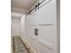 Hallway features a white barn door, hardwood floors, a gray rug and white walls at 2112 Ivey Chase Dr, Dacula, GA 30019