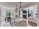 Open concept kitchen with island, modern lighting, stainless steel appliances, and adjacent dining and living areas at 2112 Ivey Chase Dr, Dacula, GA 30019