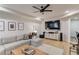 Bright living room features a comfy grey sectional, light hardwood floors, and a modern ceiling fan at 2112 Ivey Chase Dr, Dacula, GA 30019