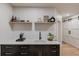 Modern wet bar features a white counter top, dark brown cabinets with golden pulls and a white subway tile backsplash at 2112 Ivey Chase Dr, Dacula, GA 30019
