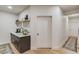 This wet bar features a white counter top, dark brown cabinets with golden pulls and a white subway tile backsplash at 2112 Ivey Chase Dr, Dacula, GA 30019