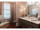 Powder room with dark wood floors, wallpaper, a window, decorative lighting, and a vanity at 101 Morgan Ln, Canton, GA 30115
