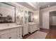 Bright bathroom boasts dual vanities, decorative sconces, and a linen cabinet on hardwood floors at 101 Morgan Ln, Canton, GA 30115