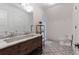 Bright bathroom featuring a dual sink vanity, decorative tile floor, and stand-alone shower at 101 Morgan Ln, Canton, GA 30115