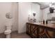 Bathroom with wood vanity, decorative sconces, a round mirror, and a toilet at 101 Morgan Ln, Canton, GA 30115