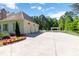 Spacious three-car garage with a long driveway and a beautifully landscaped yard and a pergola beyond at 101 Morgan Ln, Canton, GA 30115