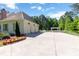 Spacious three-car garage with a large driveway and a pergola in the background at 101 Morgan Ln, Canton, GA 30115