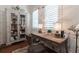 Home office featuring a wood desk, chair, bookcase, and lamp with natural light from the window at 101 Morgan Ln, Canton, GA 30115