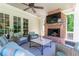 Covered porch featuring an outdoor fireplace, comfortable seating, and a ceiling fan for relaxing and entertaining at 101 Morgan Ln, Canton, GA 30115