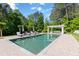 Stunning pool with brick surround and white pergola featuring lounge seating, surrounded by lush greenery at 101 Morgan Ln, Canton, GA 30115