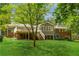 Beautiful backyard featuring a lush green lawn, mature trees, and an elevated deck with stairs at 1901 Trophy Dr, Marietta, GA 30062
