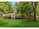A spacious backyard with mature trees and sprawling green grass, featuring an elevated deck at 1901 Trophy Dr, Marietta, GA 30062