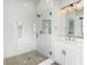Modern bathroom with a glass shower and herringbone floor pattern, plus a vanity with modern lights and fixtures at 2035 Parkside Ln, Roswell, GA 30076