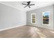 Bright, spacious bedroom with hardwood floors and two windows overlooking a green treeline at 2035 Parkside Ln, Roswell, GA 30076
