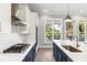 Close-up of a modern kitchen with stainless steel appliances, white backsplash, and a large island at 2035 Parkside Ln, Roswell, GA 30076