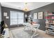 Home office with built-in shelving, a modern desk, a stylish light fixture, and a large window at 2123 Indian Ivey Ln, Dacula, GA 30019