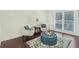 Comfortable sitting room with a tufted ottoman, cozy chairs, and natural light at 2123 Indian Ivey Ln, Dacula, GA 30019