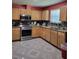 Well-lit kitchen featuring stainless steel appliances, wooden cabinetry, and tiled floors at 6071 Deerfield Ct, Morrow, GA 30260