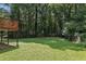 Serene backyard with a spacious lawn bordered by dense trees and greenery at 3918 Artist Vw, Decatur, GA 30034