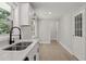 Modern kitchen with white cabinets, stainless steel sink, and light hardwood floors at 3918 Artist Vw, Decatur, GA 30034