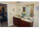 Bathroom featuring double sinks with dark wood cabinetry, large mirror, and adjacent bedroom at 504 Liverpool Dr, Mcdonough, GA 30252