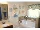 Bathroom featuring soaking tub, framed mirror, vanity with storage, and decorative window treatments at 504 Liverpool Dr, Mcdonough, GA 30252