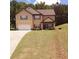 Inviting two-story home featuring a well-manicured lawn, cozy porch, and an attached two-car garage at 504 Liverpool Dr, Mcdonough, GA 30252