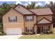 Inviting two-story home with a garage and a cozy front porch, landscaped with bushes and small trees at 504 Liverpool Dr, Mcdonough, GA 30252