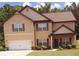 Charming two-story home with an attached garage, a lush lawn, and manicured landscaping at 504 Liverpool Dr, Mcdonough, GA 30252