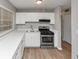 Well-lit kitchen featuring white cabinets, stainless steel appliances, and wood-look flooring at 430 Argus Nw Cir, Atlanta, GA 30331