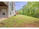 Home's backyard features a lush green lawn, mature trees, and the home's exterior at 229 Millwheel Dr, Villa Rica, GA 30180