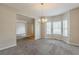 Dining room features neutral paint, plush carpet, bay window, and modern chandelier at 229 Millwheel Dr, Villa Rica, GA 30180
