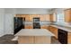 Kitchen featuring wood cabinets, black appliances, a center island and bright, natural lighting at 229 Millwheel Dr, Villa Rica, GA 30180