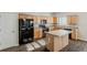 Functional kitchen featuring light wood cabinetry, black appliances, and a convenient center island at 229 Millwheel Dr, Villa Rica, GA 30180
