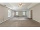 Spacious main bedroom features plush carpet, neutral paint, tray ceiling, and windows at 229 Millwheel Dr, Villa Rica, GA 30180
