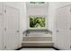 Sunlit bathtub with views of the green trees and skylight above at 601 Ashley Forest Nw Dr, Acworth, GA 30102