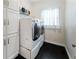Bright laundry room featuring a modern washer and dryer set, built-in shelving, and black tile floor at 601 Ashley Forest Nw Dr, Acworth, GA 30102