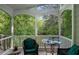 Relaxing screened porch with comfortable seating and a view of the surrounding trees at 601 Ashley Forest Nw Dr, Acworth, GA 30102