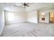 A view of an expansive bedroom with plush carpeting, ceiling fan, and ensuite bathroom at 1143 Park Hollow Ne Ln, Lawrenceville, GA 30043