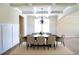 An elegant dining room featuring a decorative ceiling, modern chandelier, and space for seating eight at the table at 1143 Park Hollow Ne Ln, Lawrenceville, GA 30043