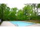 Inviting community pool surrounded by lush trees, offering a relaxing and scenic retreat at 1143 Park Hollow Ne Ln, Lawrenceville, GA 30043