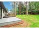 View of the home's backyard featuring a patio and wooden deck surrounded by mature trees at 117 Hillsdale Dr, Atlanta, GA 30315