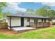 View of the home's backyard featuring a patio and wooden deck surrounded by green grass at 117 Hillsdale Dr, Atlanta, GA 30315