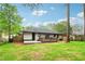 View of the home's backyard featuring a patio and wooden deck surrounded by green grass at 117 Hillsdale Dr, Atlanta, GA 30315