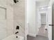 Bright bathroom featuring marble tiling, black fixtures, and soaking tub at 117 Hillsdale Dr, Atlanta, GA 30315