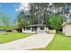 Landscaped front yard leading to a charming home with a concrete driveway and wooden accent shutters at 117 Hillsdale Dr, Atlanta, GA 30315