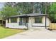 Charming home featuring a painted brick exterior, black trim, wooden shutters, and a well-manicured lawn at 117 Hillsdale Dr, Atlanta, GA 30315