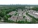 An aerial view shows rooftops of townhomes surrounded by lush green trees with a city skyline in the distance at 247 Franklin Rd, Atlanta, GA 30342