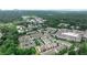 An aerial view shows rooftops of townhomes surrounded by lush green trees with a city skyline in the distance at 247 Franklin Rd, Atlanta, GA 30342